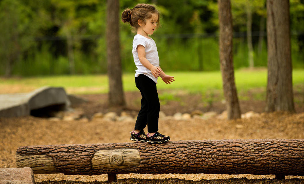 Child jumping in front of an obstacle course