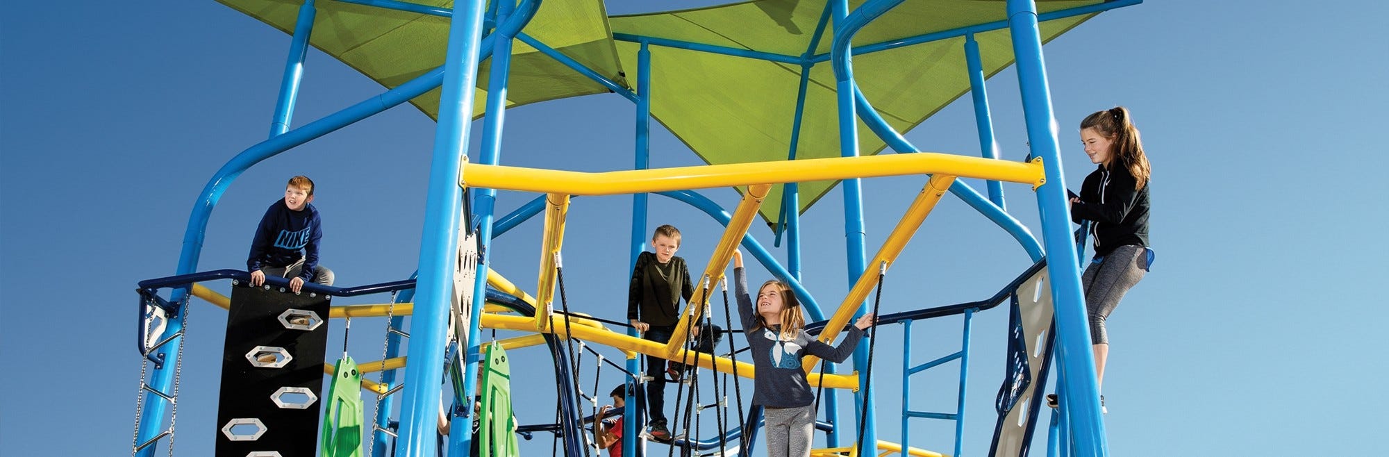 Children climb and explore a playground system