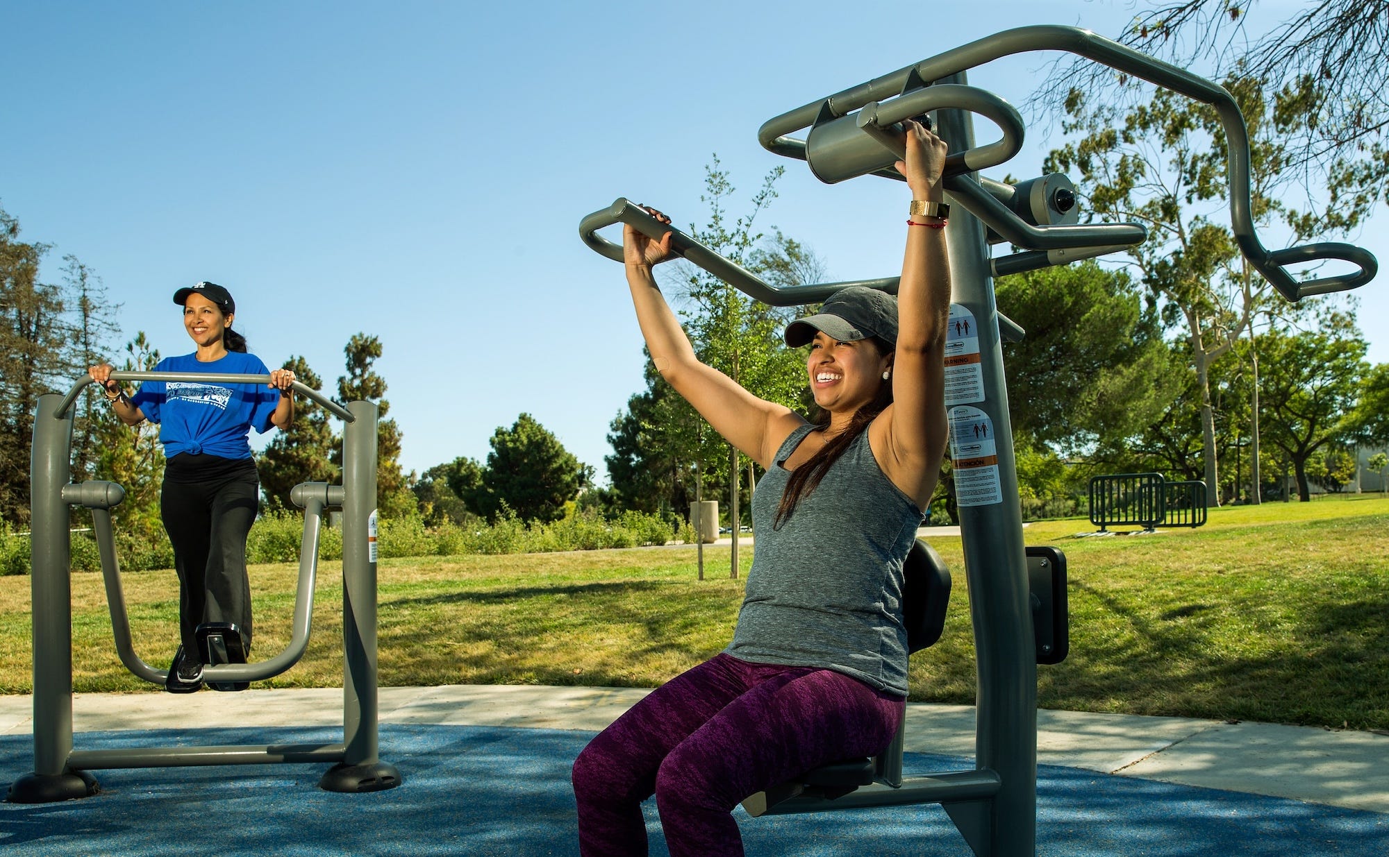 Women exercising outdoor with outdoor fitness equipment