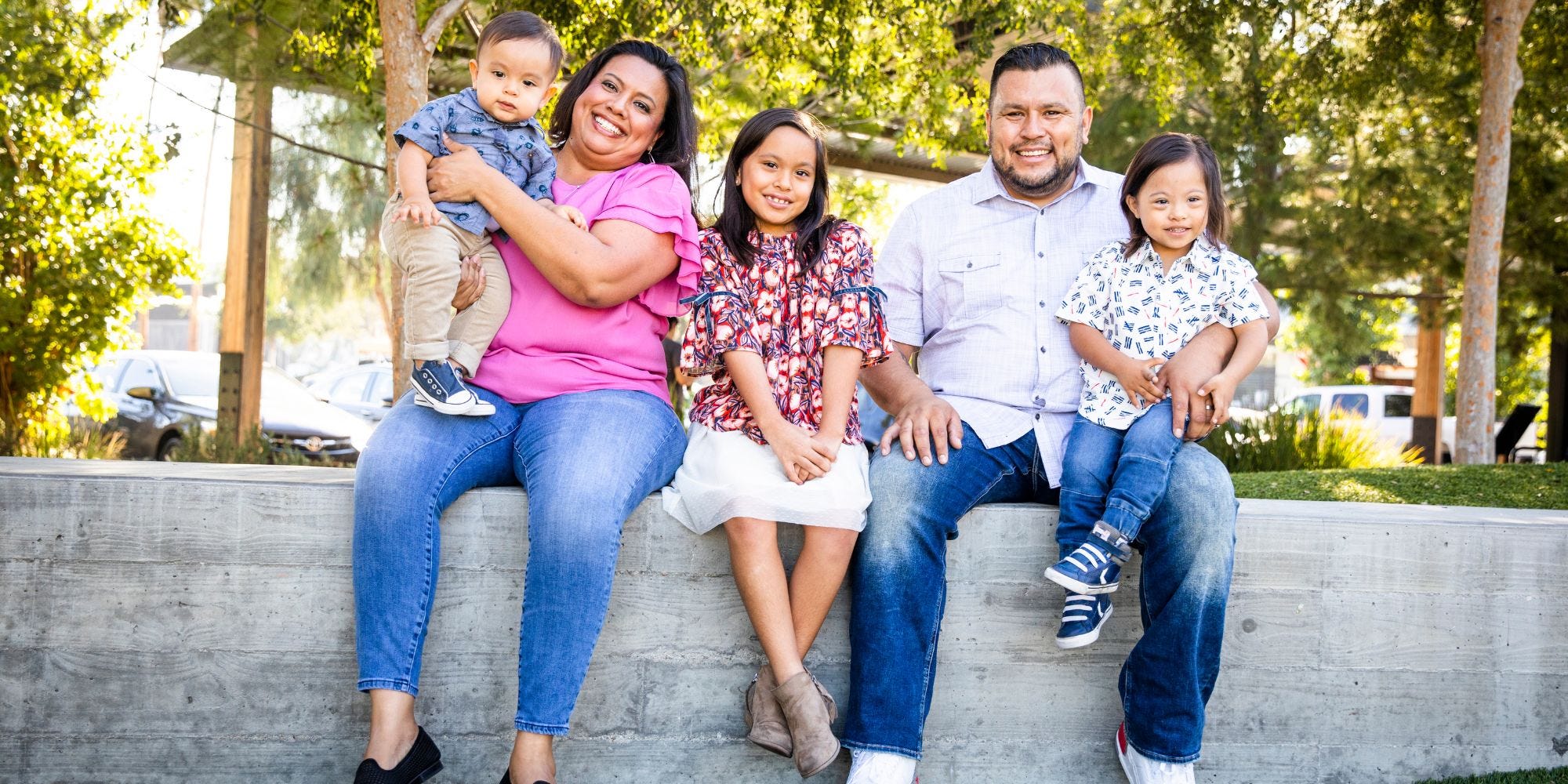 family sitting in a community park