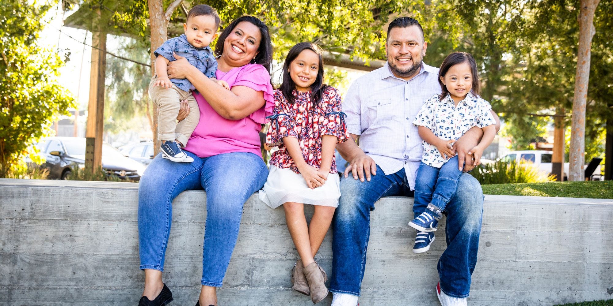 family sitting in a community park