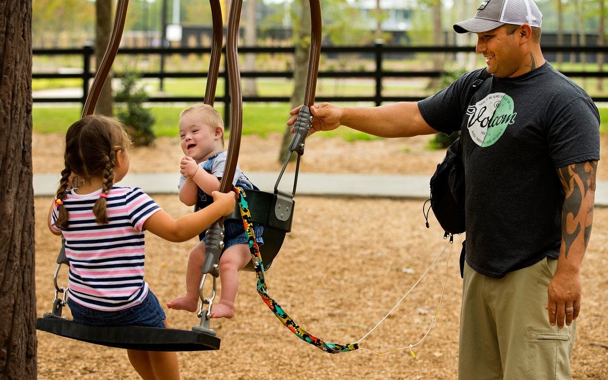 Two children swinging while facing each other in opposing swings