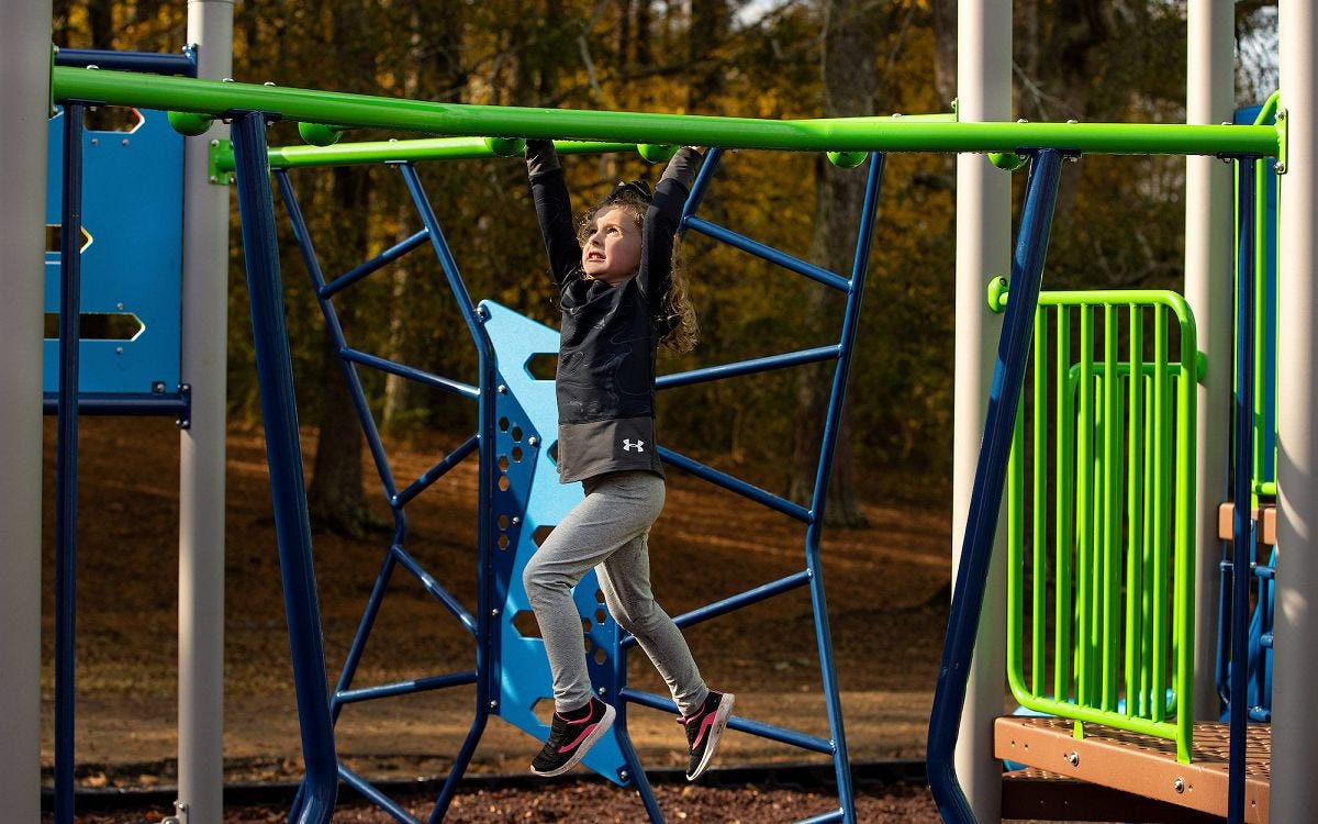 FitKid by GameTime Child traversing through an overhead climber