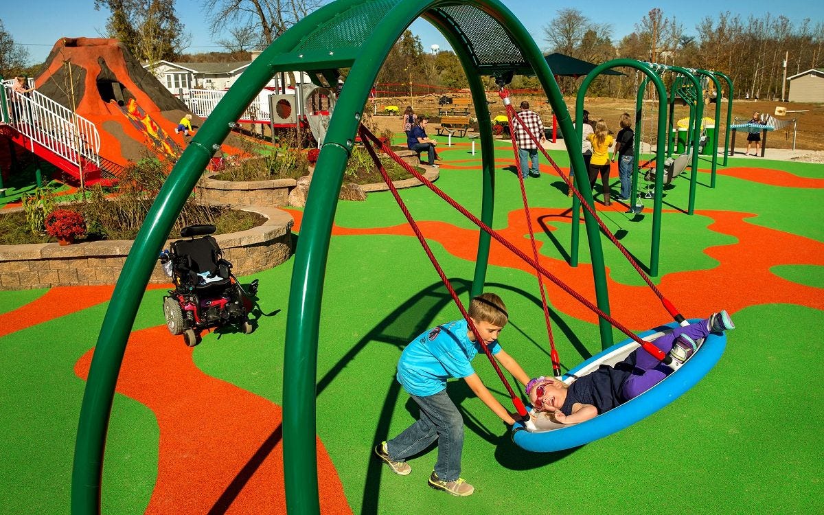 Arch Swing by GameTime Child laying in circular swing while another child pushes