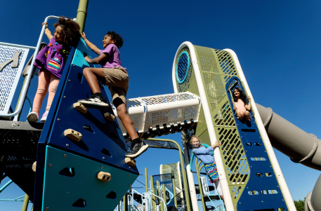 Children playing on commercial playground equipment at a community park