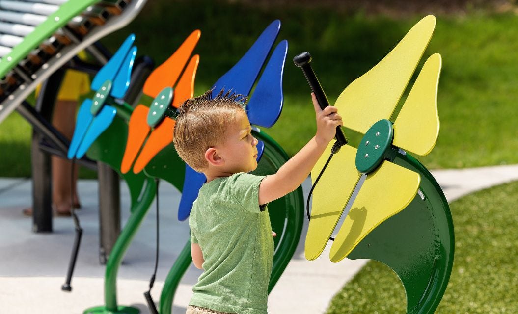 Blue, red, and yellow accessible play system with ramped access