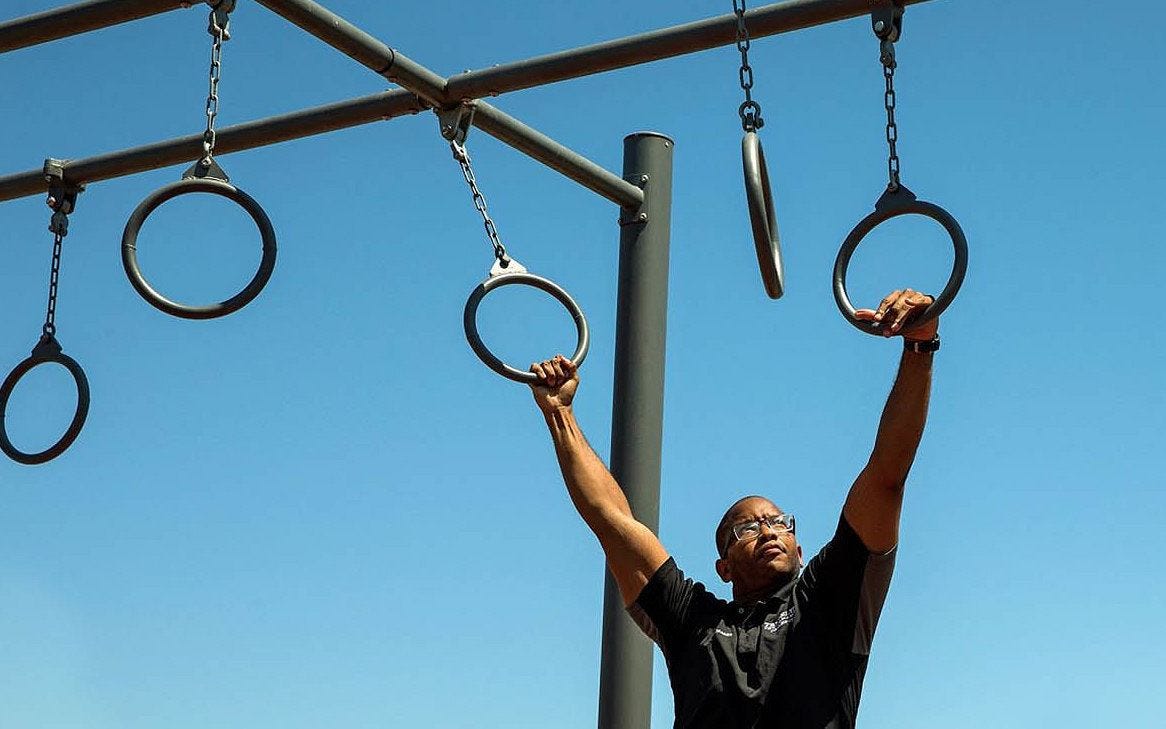 Man traversing through overhead rings
