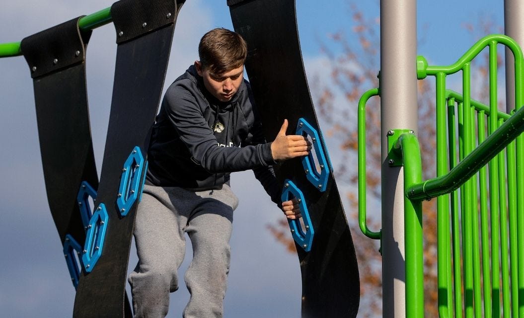 Mother and child swinging while facing each other in opposing swings